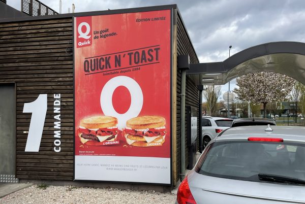 Affiche Quick’N Toast installée sur un caisson aluminium en drive-in.